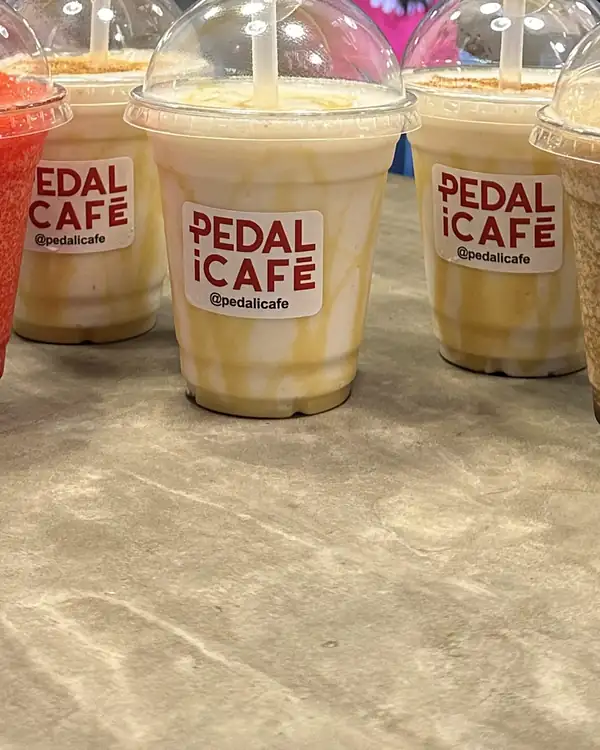 Fila de granizados de colores en vasos de PEDALiCAFÉ sobre la barra